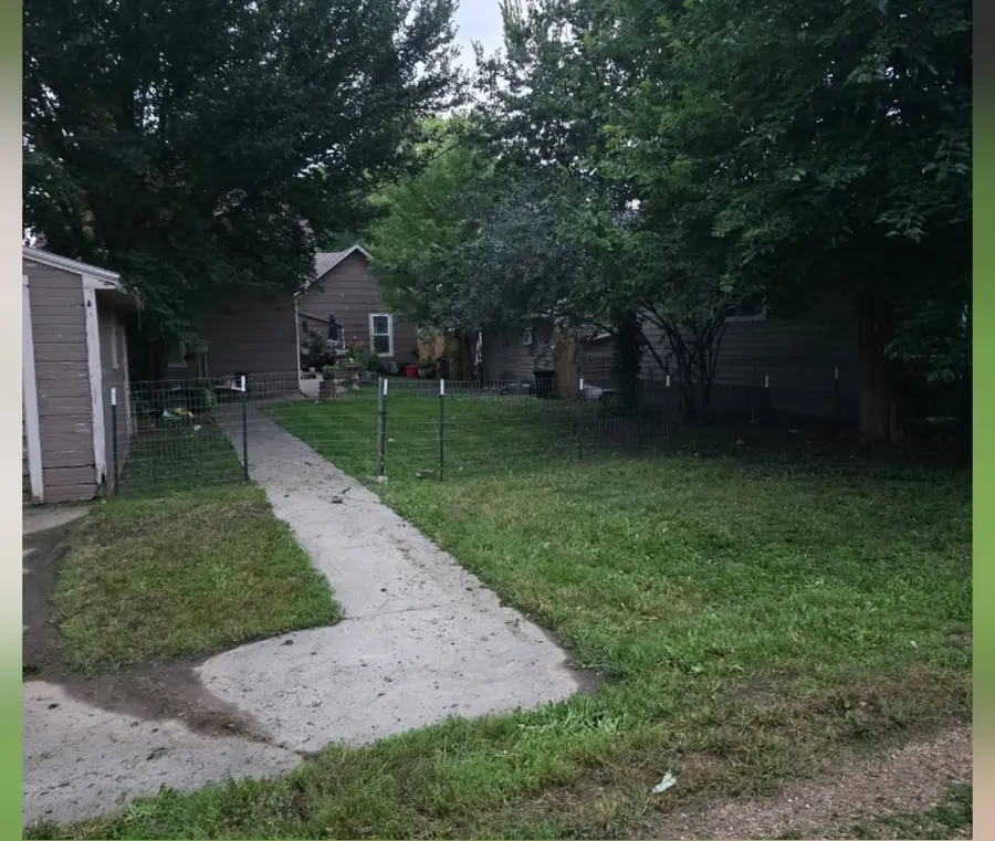 The same backyard mown short with the path edges trimmed, after