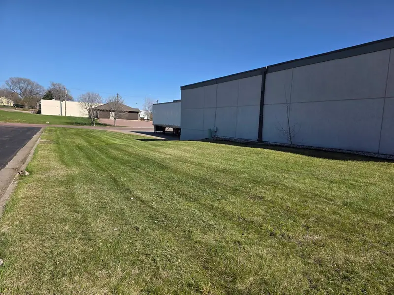 A long strip of mown lawn behind a commercial building in Mitchell