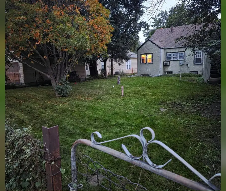 The same sloping backyard mown clean in the evening, after
